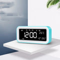 Blue rectangular LED atmosphere light and digital alarm clock on a table.