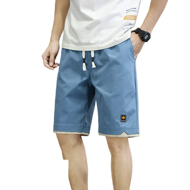 Man wearing straight loose fit beach shorts in 8905 green, made from micro elasticity polyester fabric.
