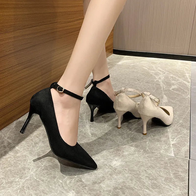 Women's black stiletto heel pump shoe with a silver buckle detail on the side.
