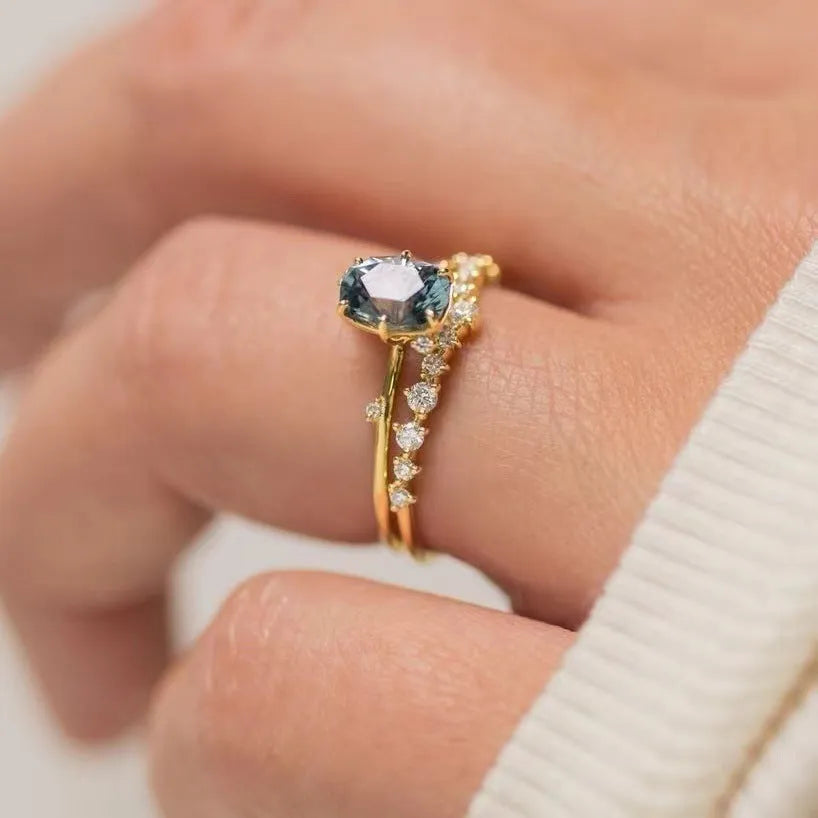 Gold-coloured floral fashion ring with a central green zircon stone on a white background.