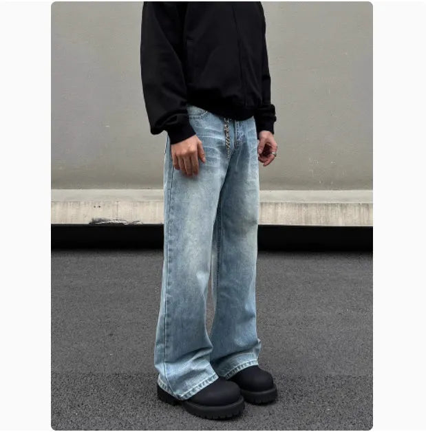 Man wearing blue straight leg jeans with whisker wash detailing and a flared leg style.