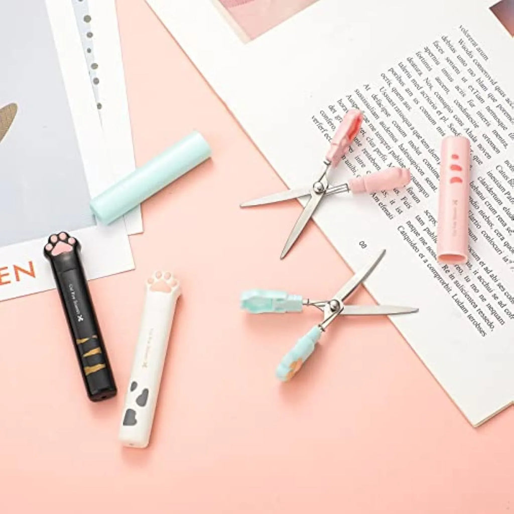 Mini folding scissors with cat paw design on handle, shown in pink, white, black, and blue colour options.