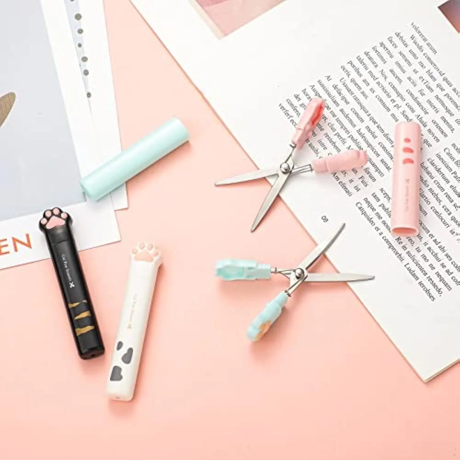 Mini folding scissors with cat paw design on handle, shown in pink, white, black, and blue colour options.