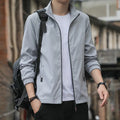 Man wearing a black Korean-style loose lapel casual jacket with zipper pockets.