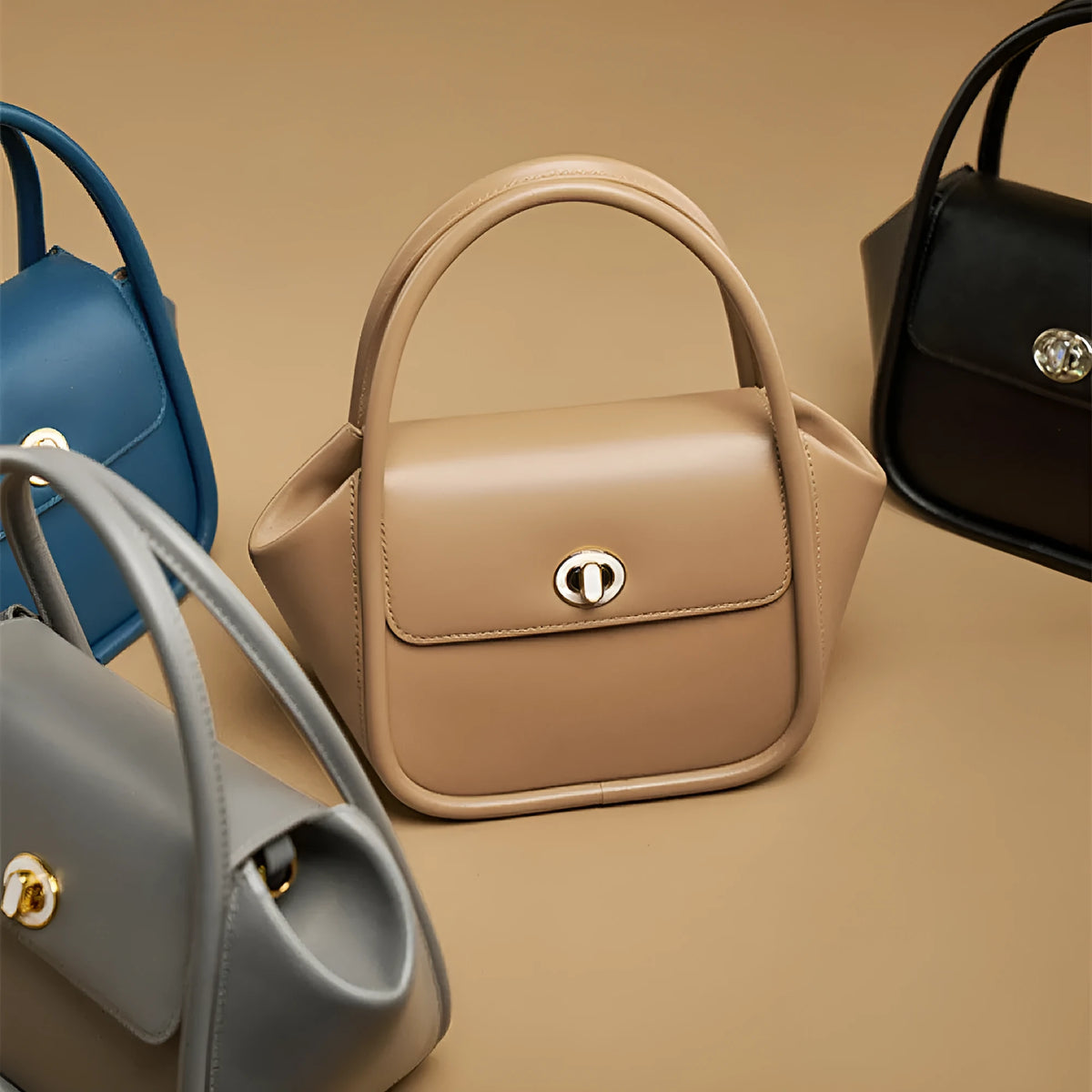 Women's winged leather handbag with cross-body strap in blue, showing latch closure and buckle detail.