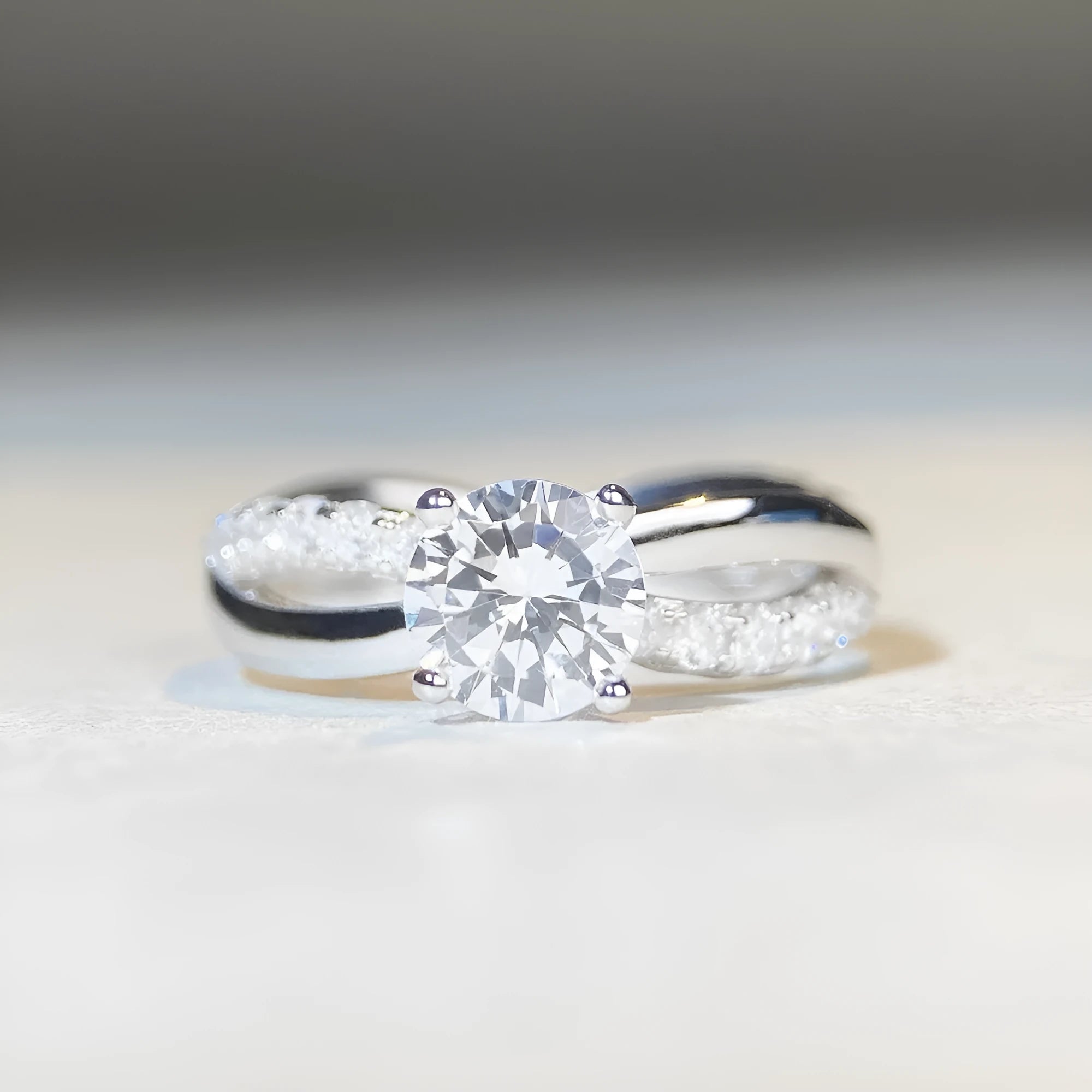 Silver geometric ring with a twisted band, a cross design, and a 1 karat moissanite in a four-claw setting.