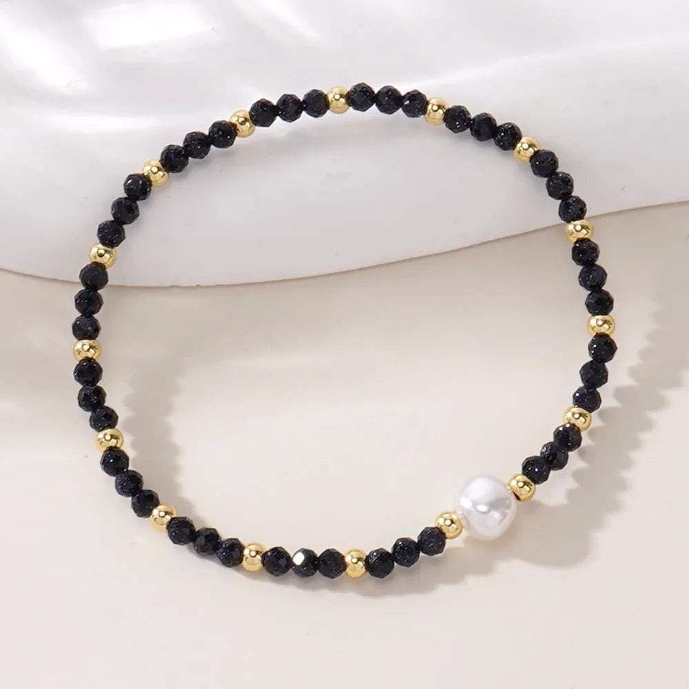 A natural stone bracelet with a geometric ellipse shape on a wrist.
