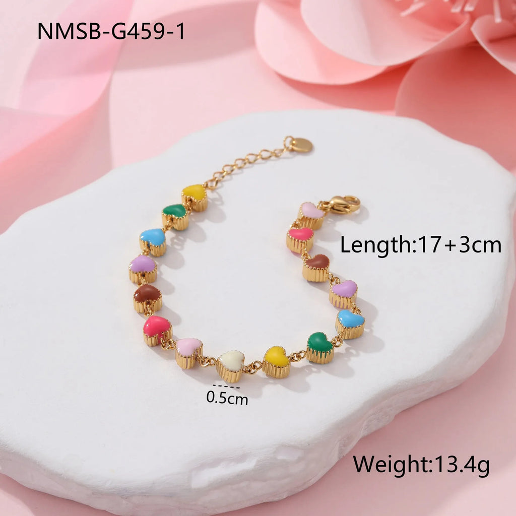 Close-up of a women's stainless steel bracelet with a colourful, heart-shaped titanium steel pendant.