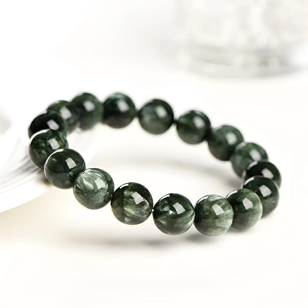 Green Dragon Crystal bracelet with round beads and a central Ruyi knot on a wrist.