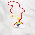 Handmade crocheted car pendant featuring a colourful avocado and rainbow flower design in wool yarn.