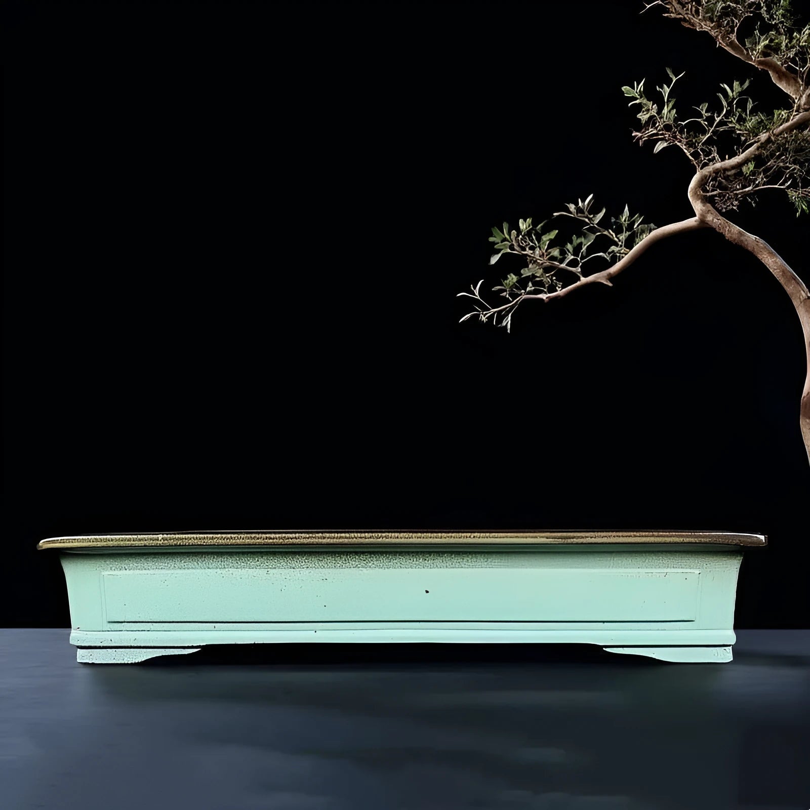 Handmade retro green ceramic bonsai flower pot with crackled glaze on a surface.