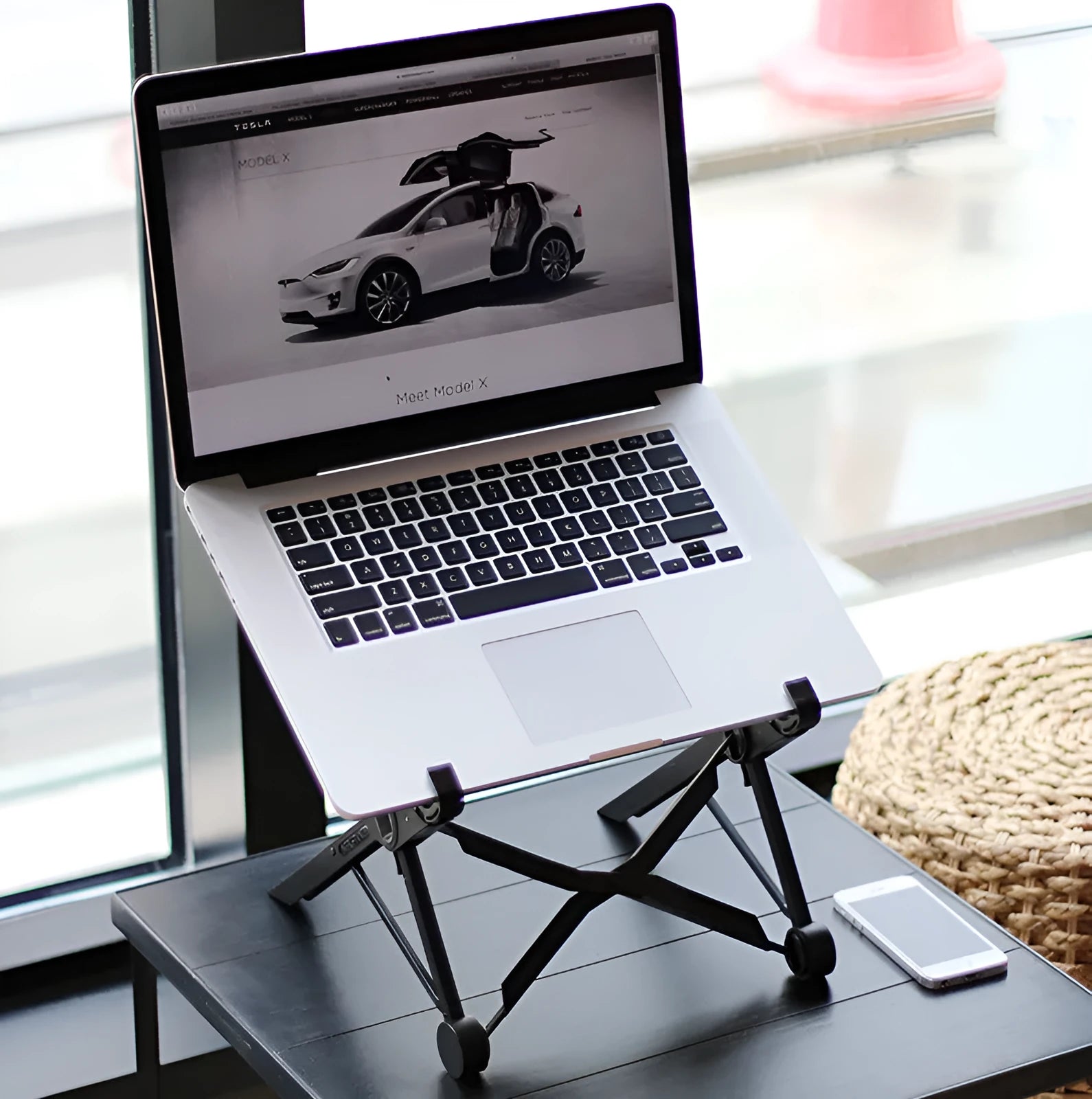 Black folding portable laptop stand showing reinforced nylon construction and compact folded dimensions