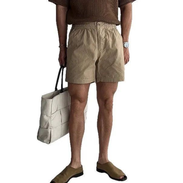 Men's loose-fit cotton sports shorts in black, shown on a model.