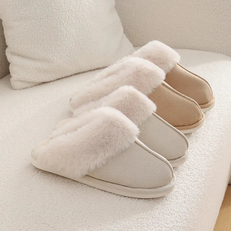 Women's plush winter slippers in pink with a round toe, flat heel, and decorative stitching.