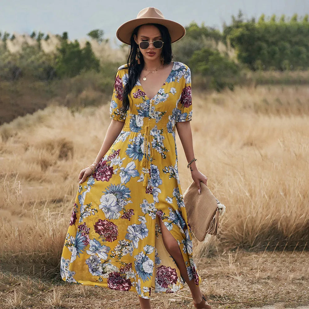Yellow floral print summer dress with V-neck, short sleeves, and an elastic high waist on a mannequin.