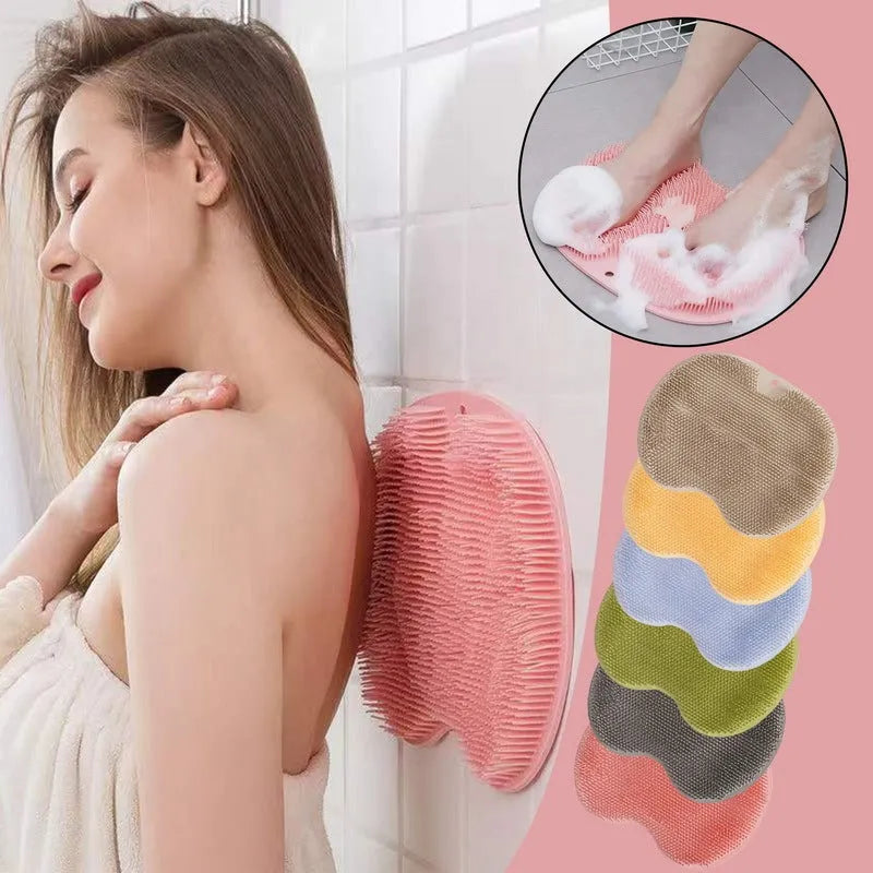 Orange silicone bristle bath brush with suction cup base on bathroom tiles.