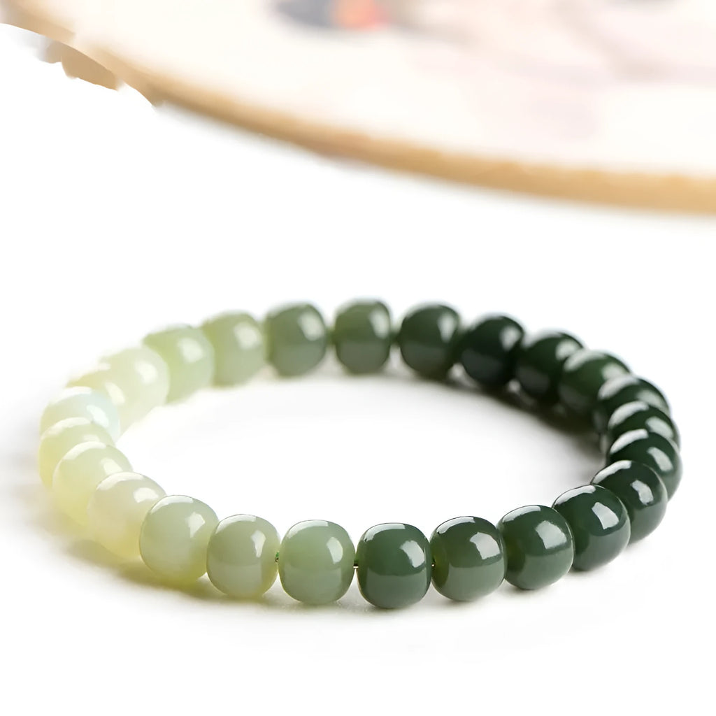 Natural Hetian jade bracelet showing gradient water colour and polished oval beads.