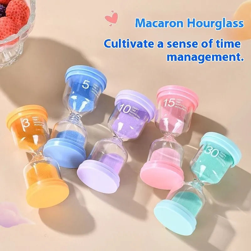 Handmade glass sand timer with coloured purple sand on a wooden desk.