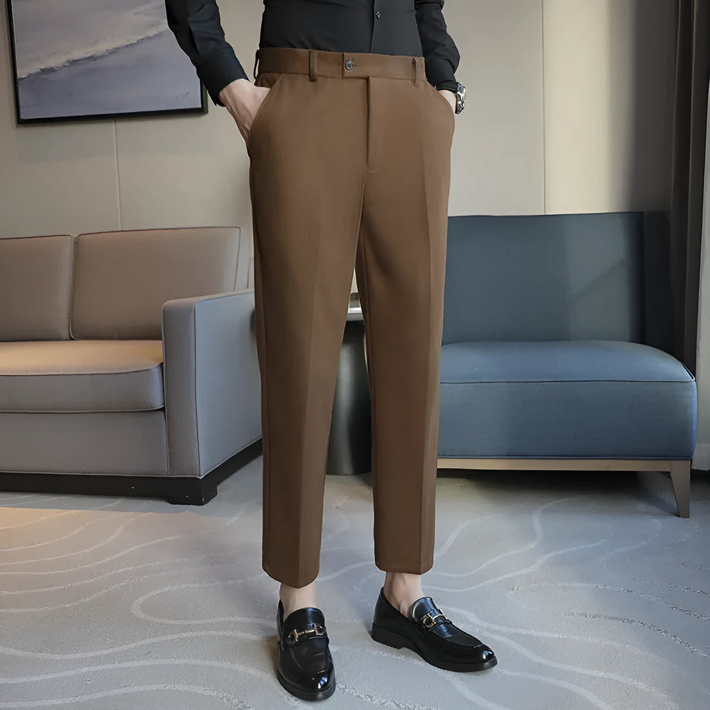Brown straight leg corduroy trousers for men laid flat, showing slim fit and elastic waistband detail.