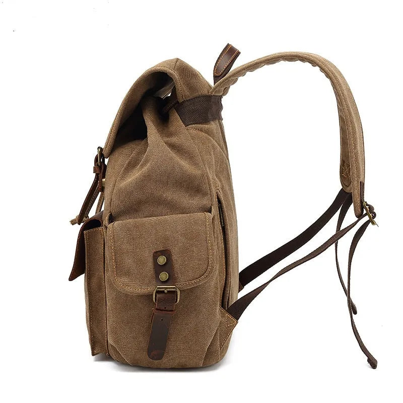 Retro-style canvas backpack in military green with antique bronze hardware, shown with a 16-inch laptop.