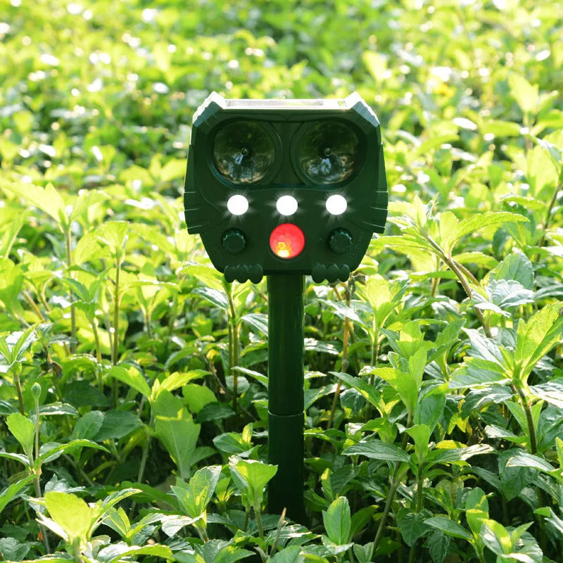 Green solar ultrasonic animal repeller unit showing dimensions and outdoor installation.
