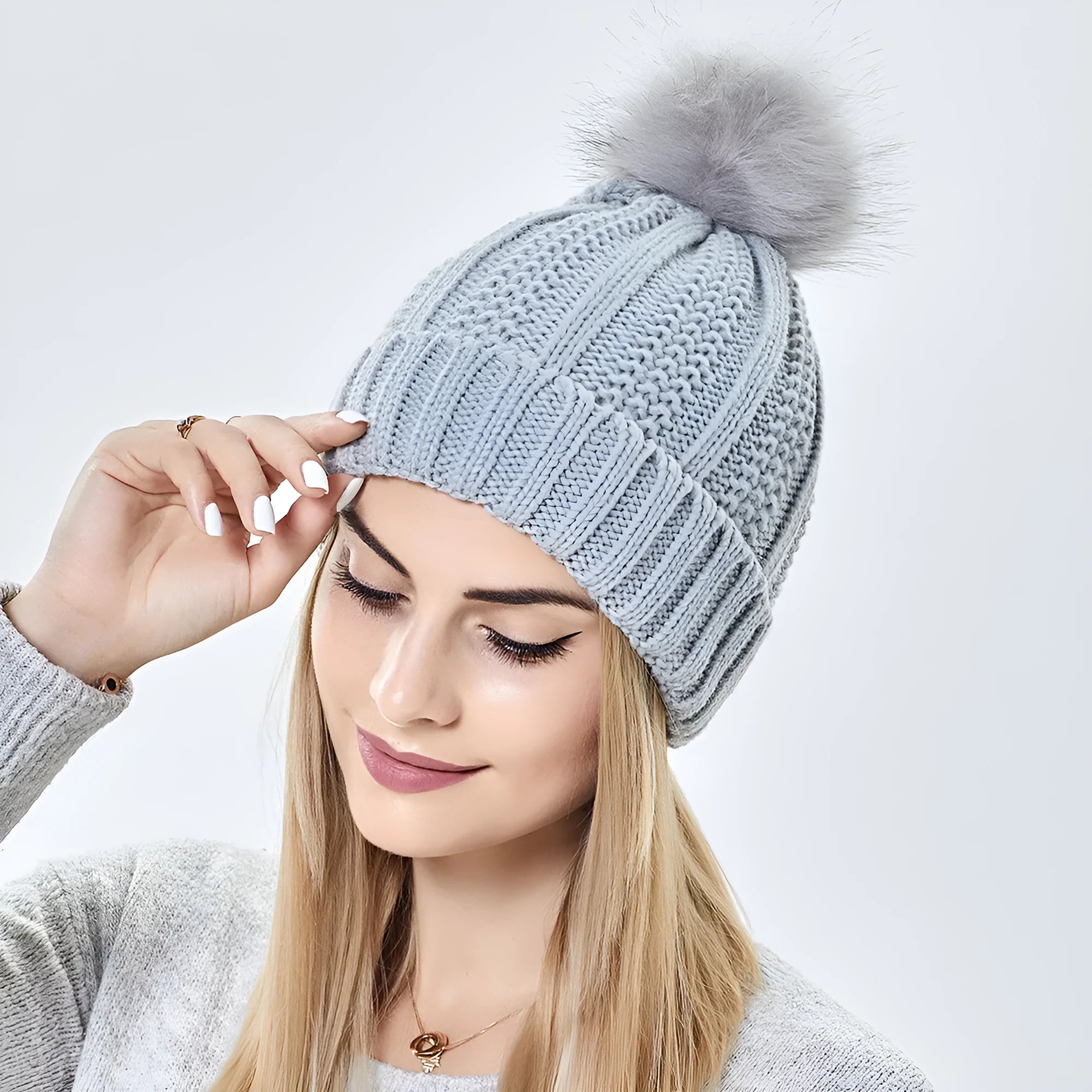 Women's knitted beanie hat with faux fur pom pom and satin lining in a choice of eight colours.