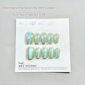 Set of electroplated Cat's Eye false nails with aurora shine in short square stiletto shapes on a clear stand.