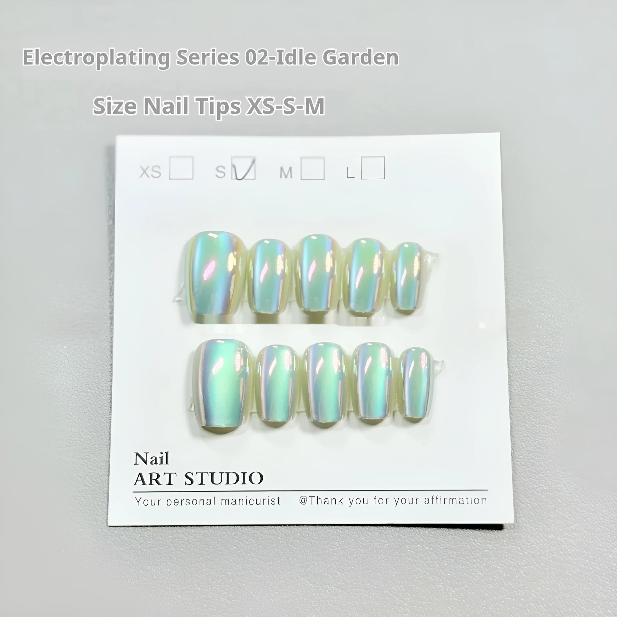 Set of electroplated Cat's Eye false nails with aurora shine in short square stiletto shapes on a clear stand.
