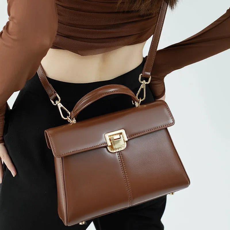 Genuine leather women's shoulder bag with clasp closure showing interior hidden compartment