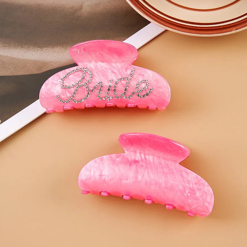 Pink and white acrylic shower shark hair clips with diamond embellishments and English letter details