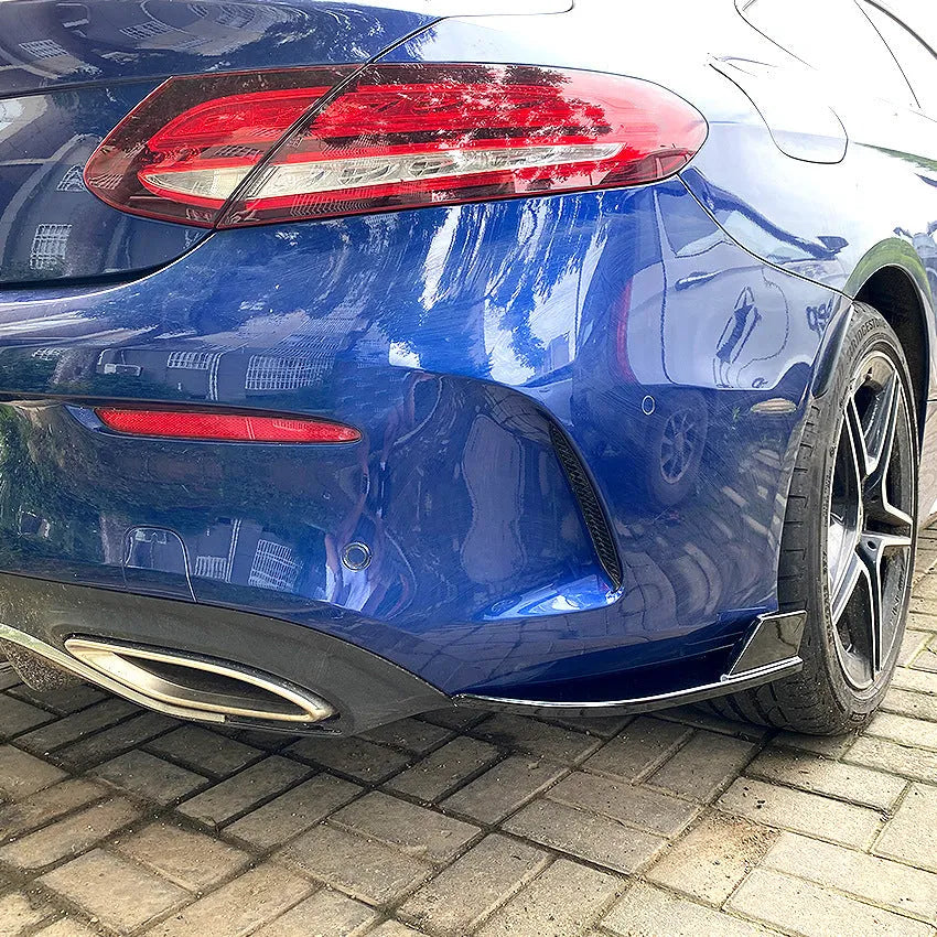 Pair of car rear bumper corner protectors in carbon fibre pattern on a vehicle rear corner