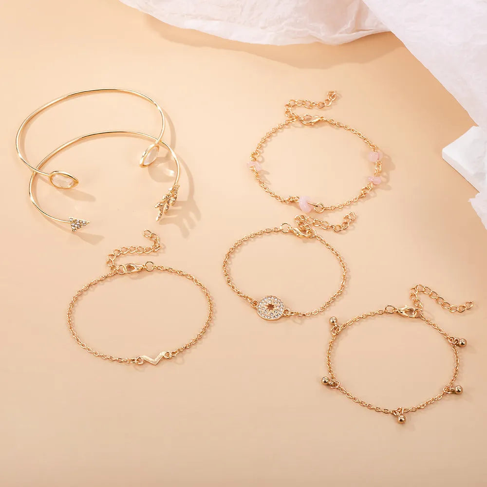 Gold-coloured six-piece bracelet set with arrow and water drop shapes featuring spot drill detailing