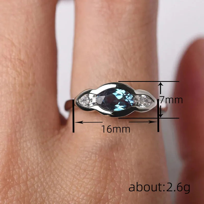 Geometric ellipse-shaped women's ring with zircon inlay in a white gold finish, shown on a hand.