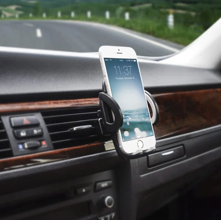 Black plastic car mobile phone holder mounted on air conditioning vent holding smartphone
