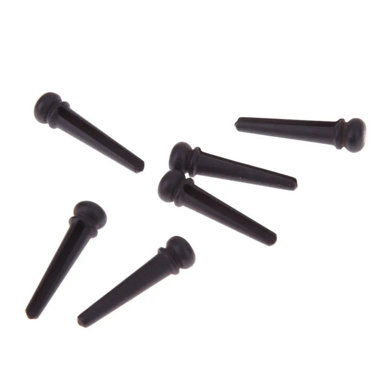 Six ebony guitar string nails with matt black finish and 5.3mm bayonet diameter