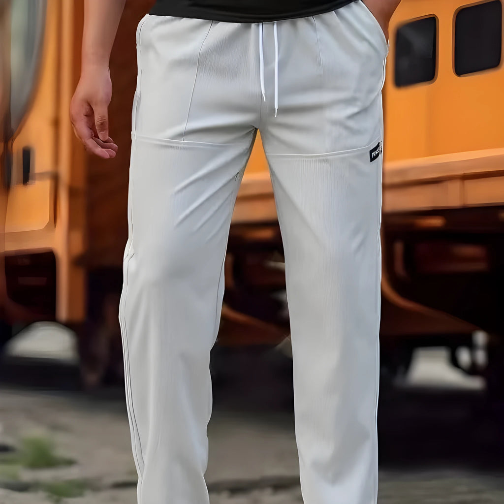 Men's light grey polyester trousers for spring and autumn seasons laid flat.