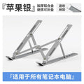 Silver aluminium laptop stand folded next to an open laptop, showing its portable size.