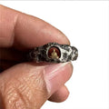 Hand-forged copper Grotto Buddha ring with rock texture on a size 8 finger.