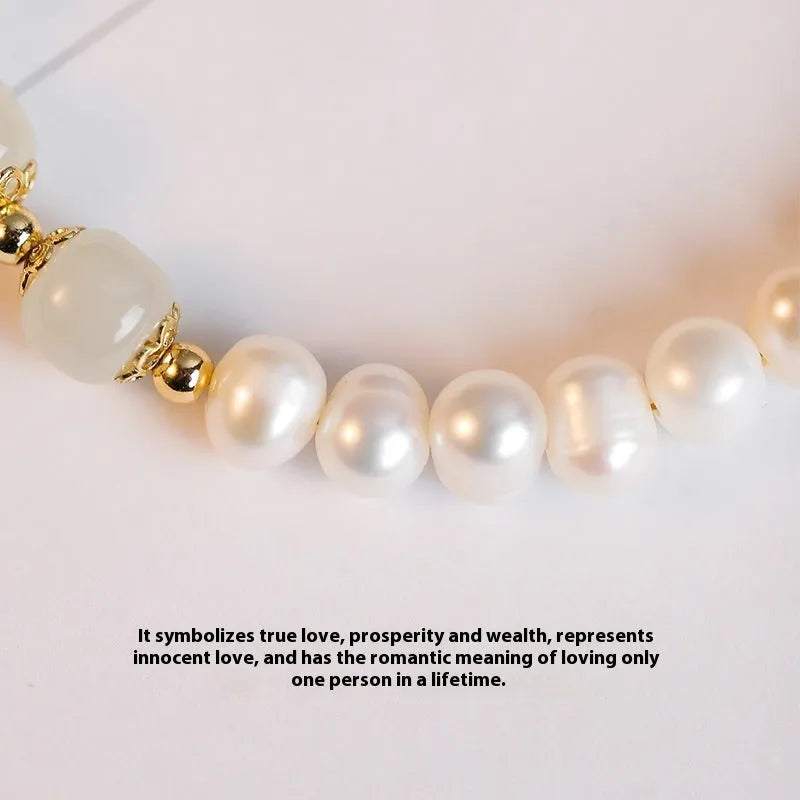 Natural freshwater pearl bracelet with diamond-shaped beads in Hetian jade colour on a wrist.