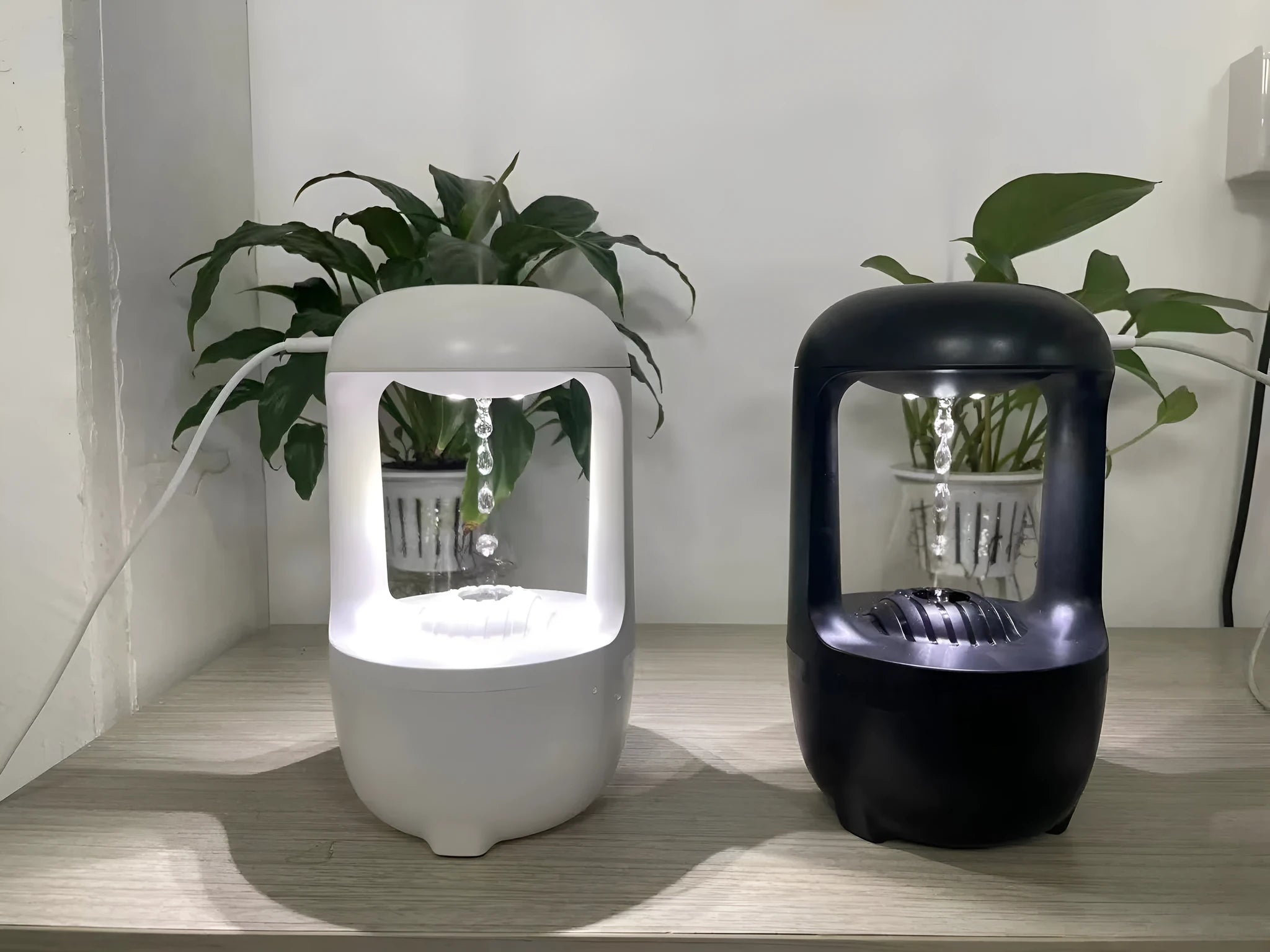 White anti-gravity humidifier showing water drop backflow effect with USB cable connection