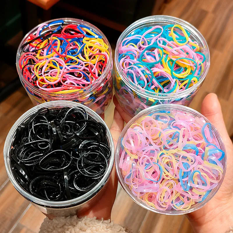 Pack of multicolour TPU baby hair ties in a reusable plastic storage container.