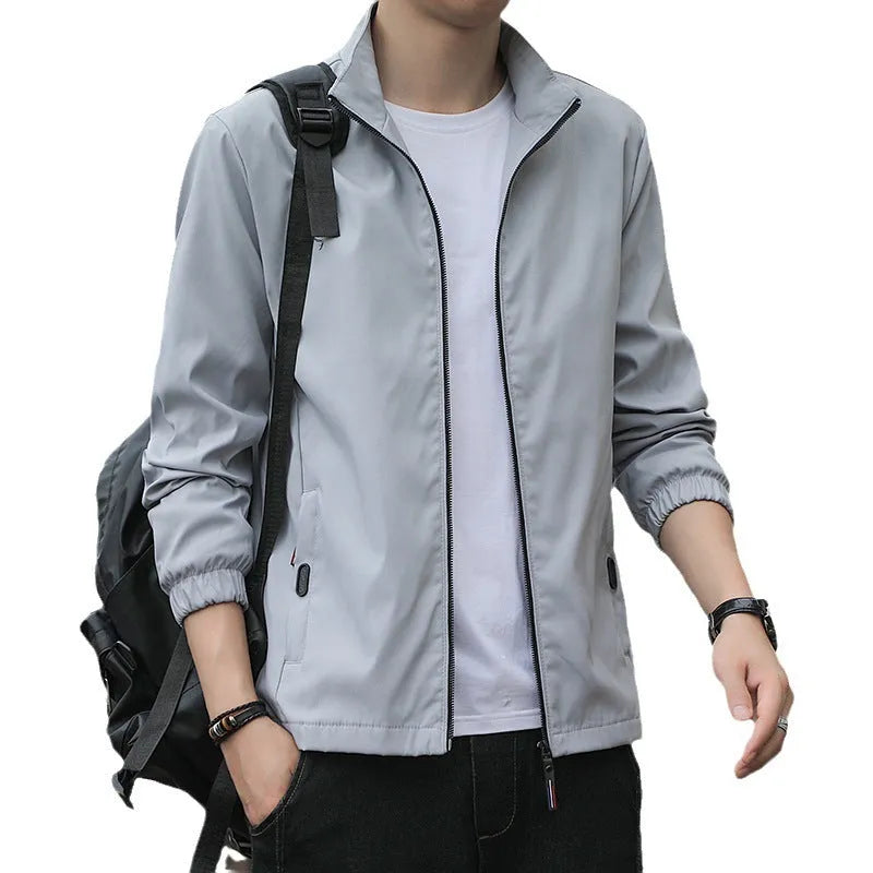 Man wearing a black Korean-style loose lapel casual jacket with zipper pockets.