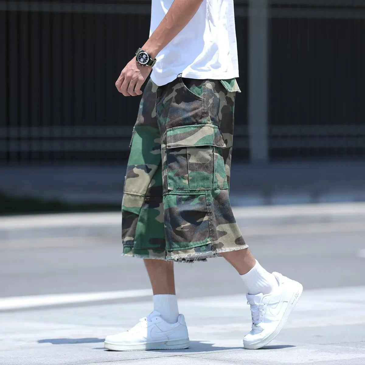 American style retro workwear loose camouflage shorts in cropped length on a neutral background.