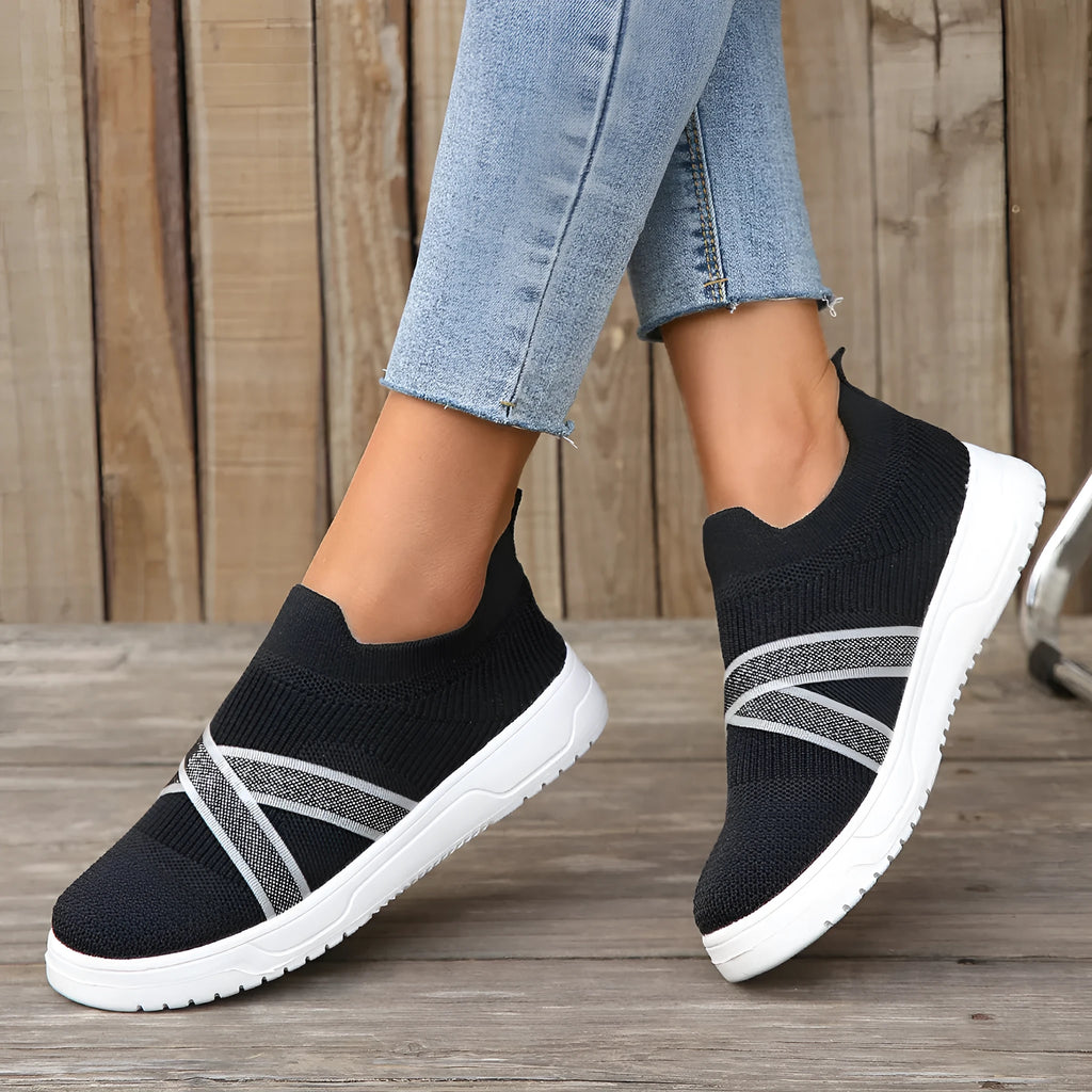 Black women's flat shoes with flyknit mesh upper, round toe, tassel detail, and rubber sole.