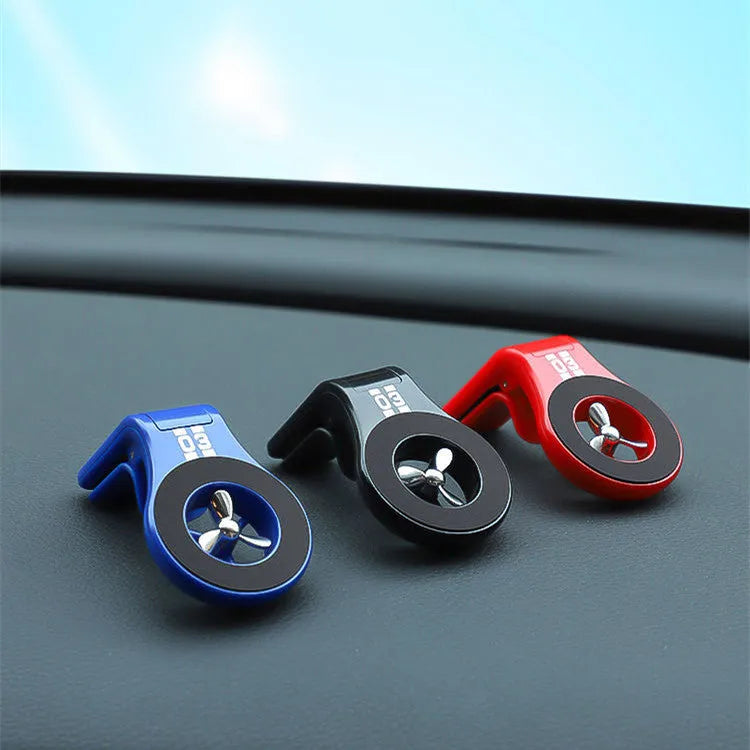Black magnetic car phone holder clipped to car air vent with smartphone attached and fragrance pads