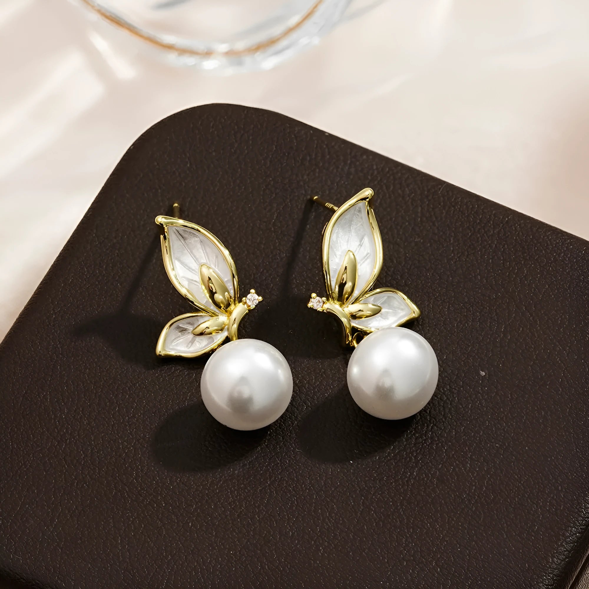 Close-up of a pair of zircon painting oil finish butterfly stud earrings on a copper base, style PT0203.