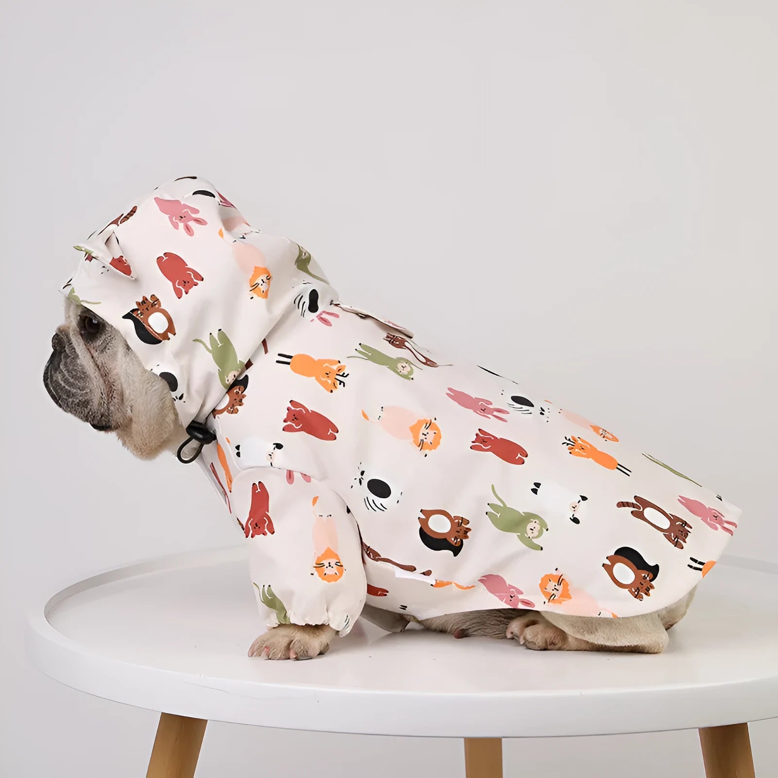 Beige dog raincoat with a cartoon animal print, showing sizing options for waterproof pet wear.