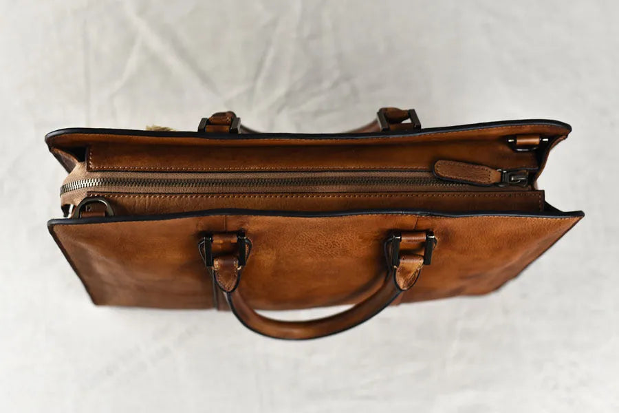 Men's brown leather horizontal business handbag with zipper closure shown from the front.