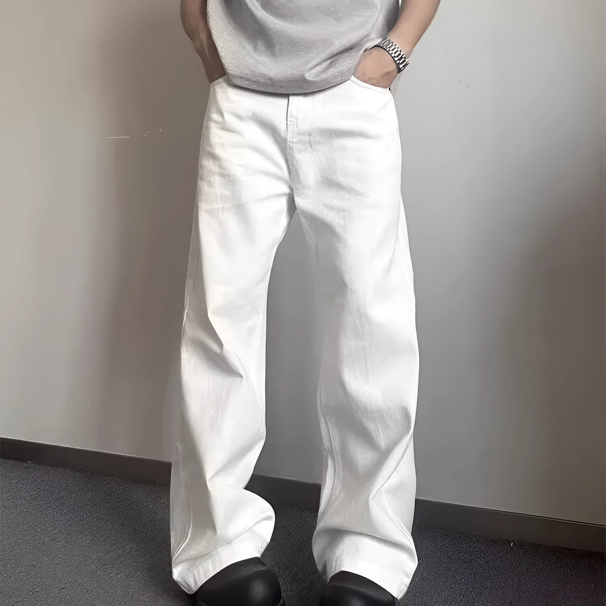 Men's white straight-leg wide-cut denim jeans on a plain background, showing front and side views.
