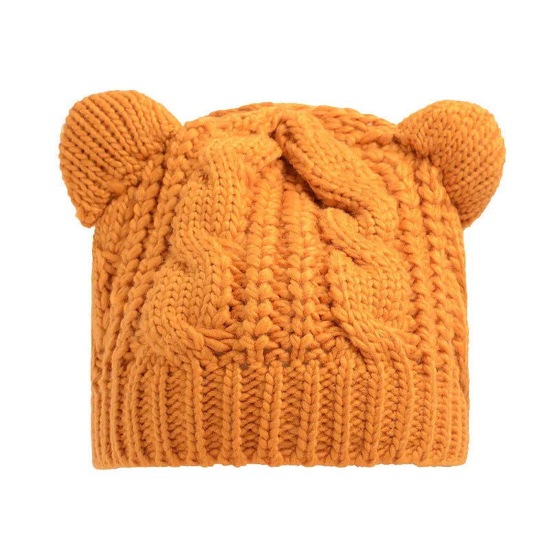 Hand-knitted red wool beanie with 3D cat ears on adult model in winter setting